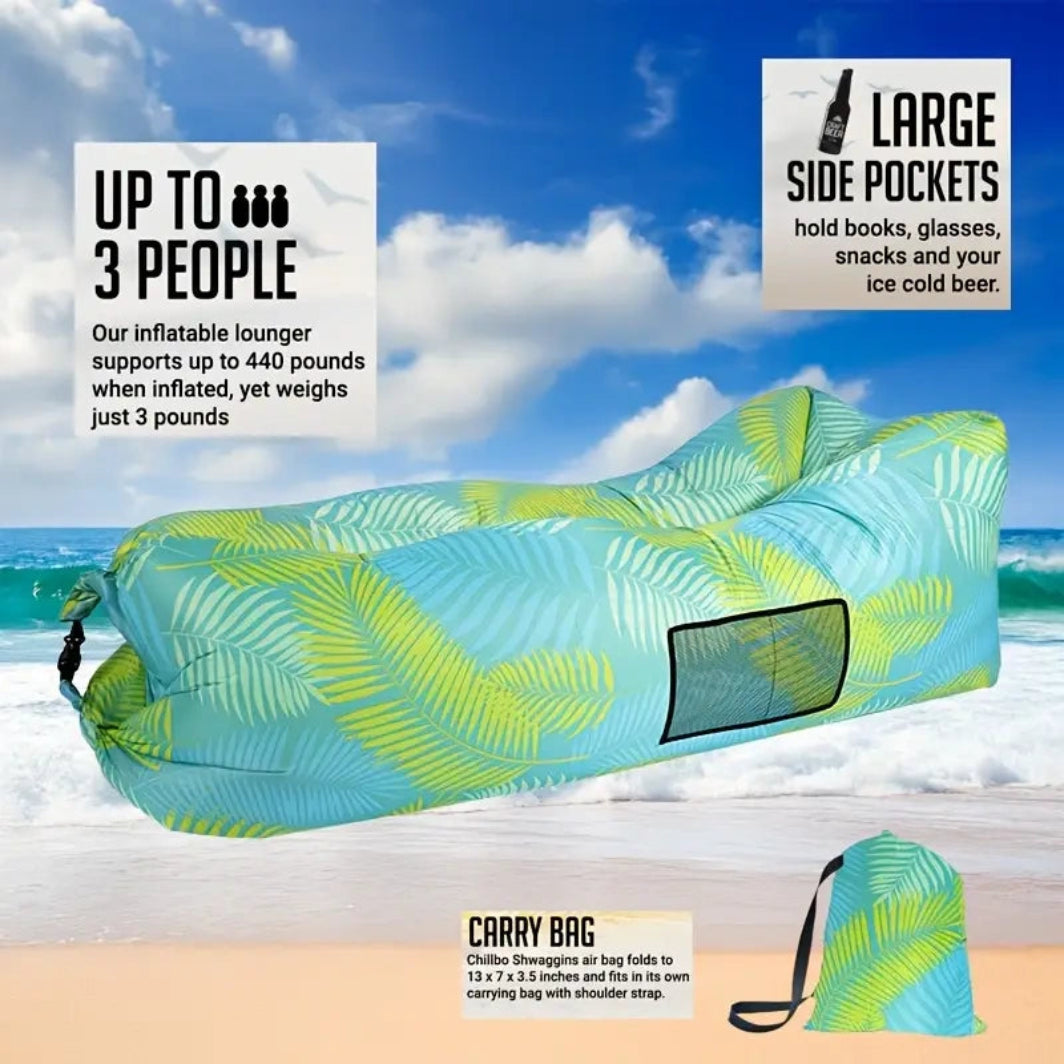 Inflatable lounge chair with palm leaf pattern on a beach, featuring text about capacity and features.