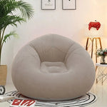 Load image into Gallery viewer, Beige bean bag chair in a room with a plant, lamp, and table.
